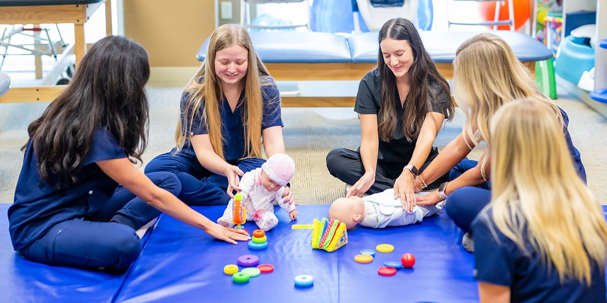 Group of Occupational Therapy students with two baby dolls