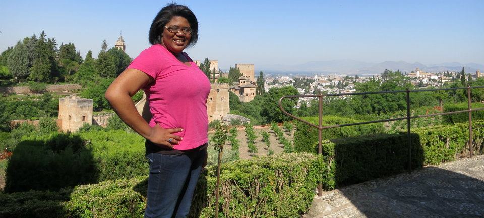 Female student standing outside in garden studying abroad.