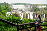 Student smiling in front of waterfall.