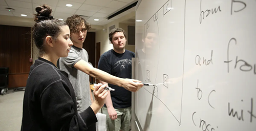 Students working at the white board,