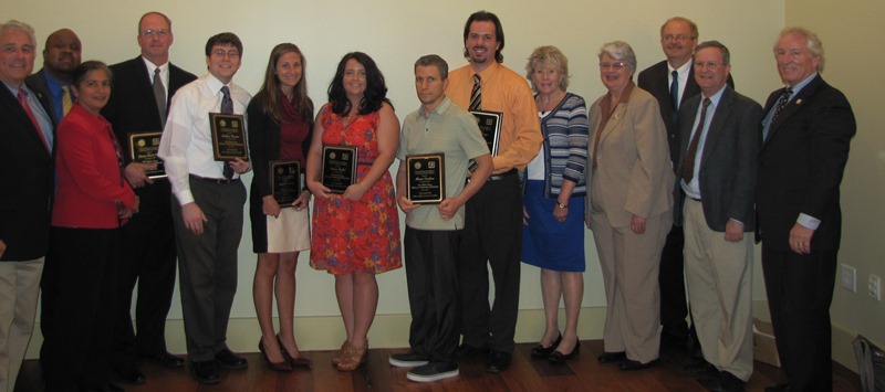 Scholarship recipients holding plaques.