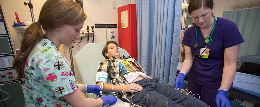 Two female nurses working with patient