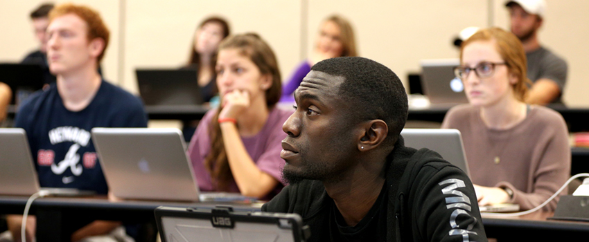 Students sitting in classroom listening to lecture.