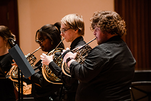 Three students playing brass instruments.