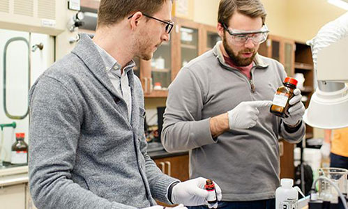 Two chemical engineering students working in classroom.