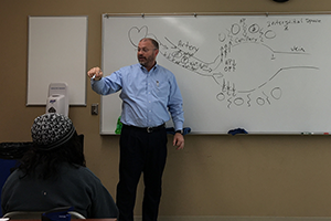 Chemistry professor teaching at white board.