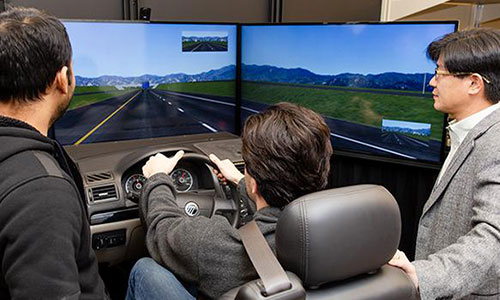 Civil Engineering student with professor driving simulator.