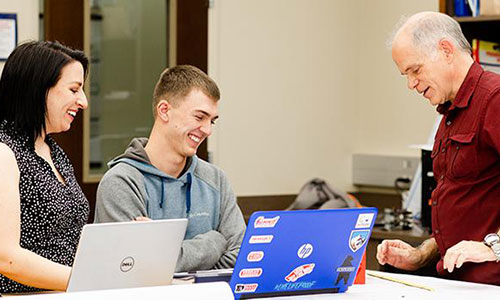 Professor working with student on laptop