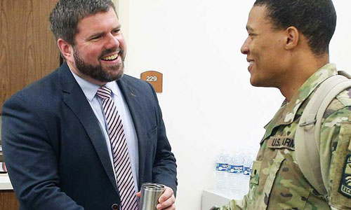 man in suit talking to man in military uniform
