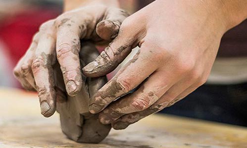 Hands molding clay