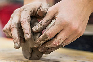 Hands molding clay