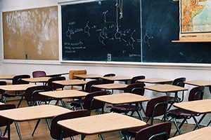 Classroom showing desks, board, and map.