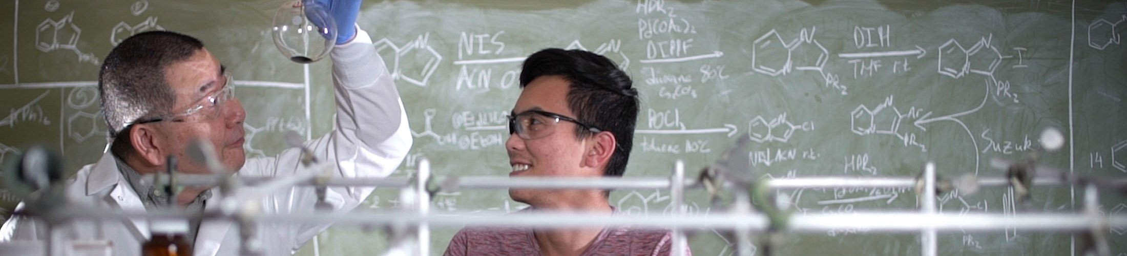 Male student working in lab with professor