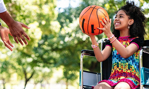 young girl in wheelchair throwing basketball