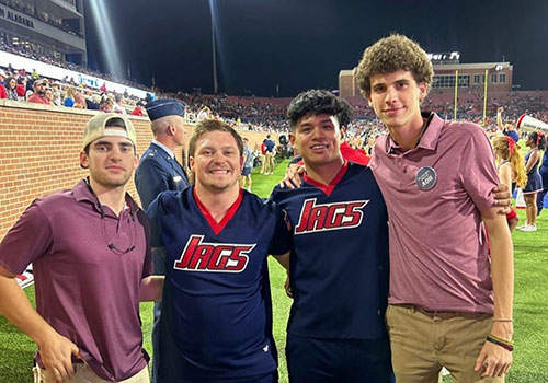 Two IFC members with their arm over each other outside at an event.