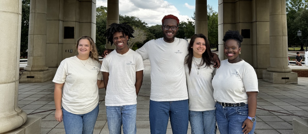 A group of students outdoors standing and posing for the camera.