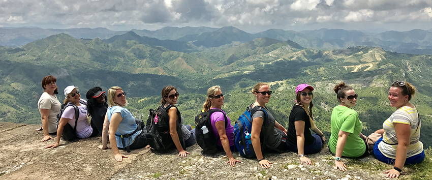 A group sitting on the edge looking over a valley