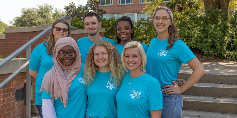 A group of students outdoors standing and posing for the camera.