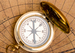 navigational compass sitting on a map