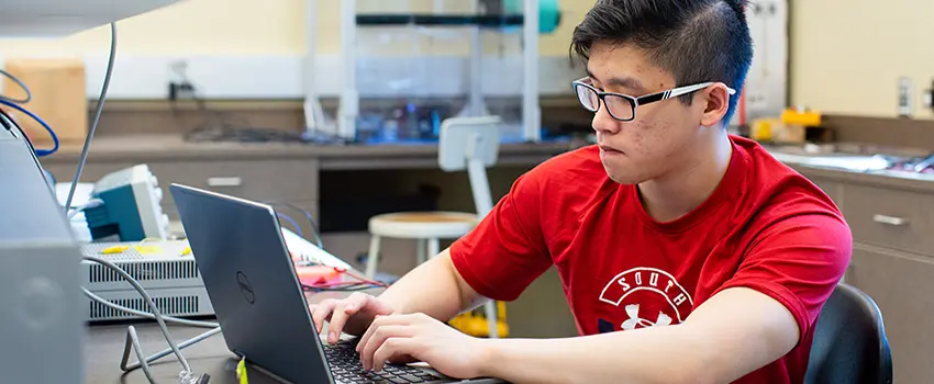 Male student working at computer in Engineering lab.